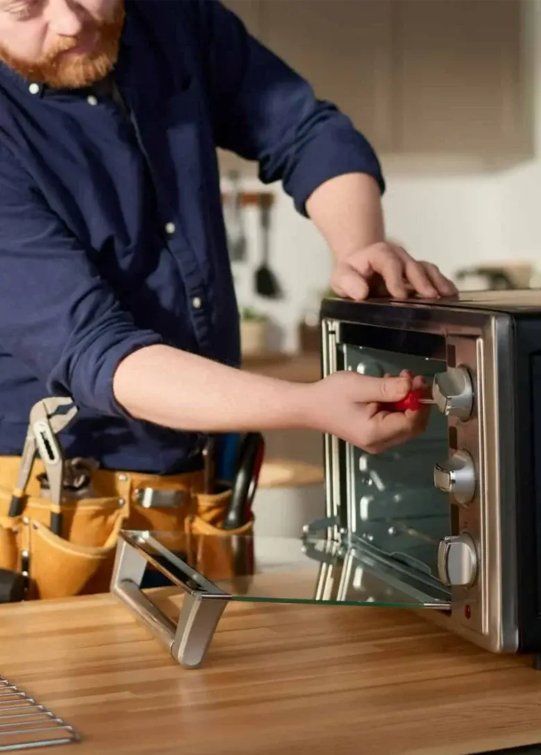Professional technician inspecting an appliance part in workshop